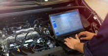 Mechanic with computer check of vehicle.
